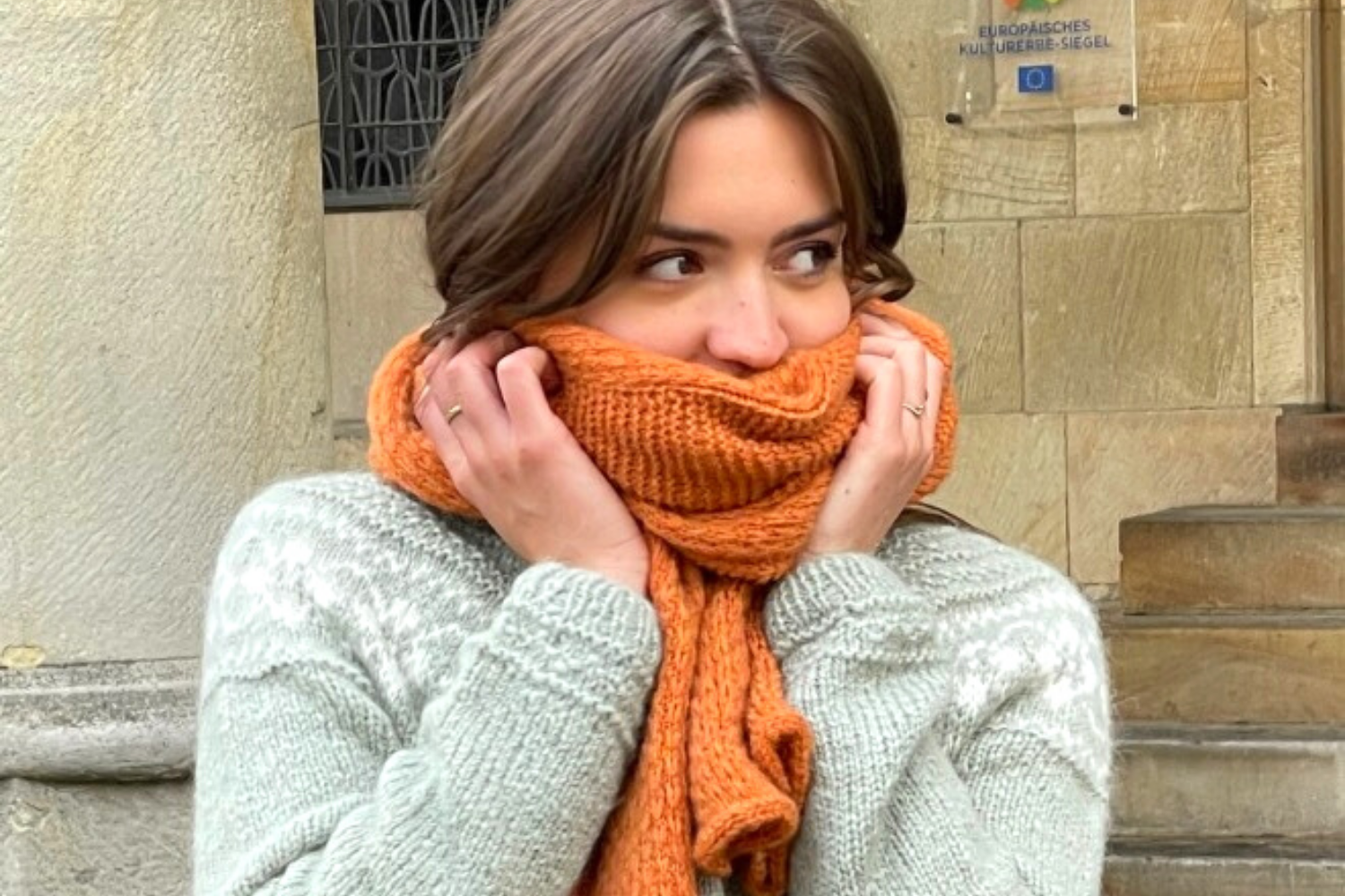 Weicher Mustermix Schal getragen. Selbstgestrickt in orange und grau.