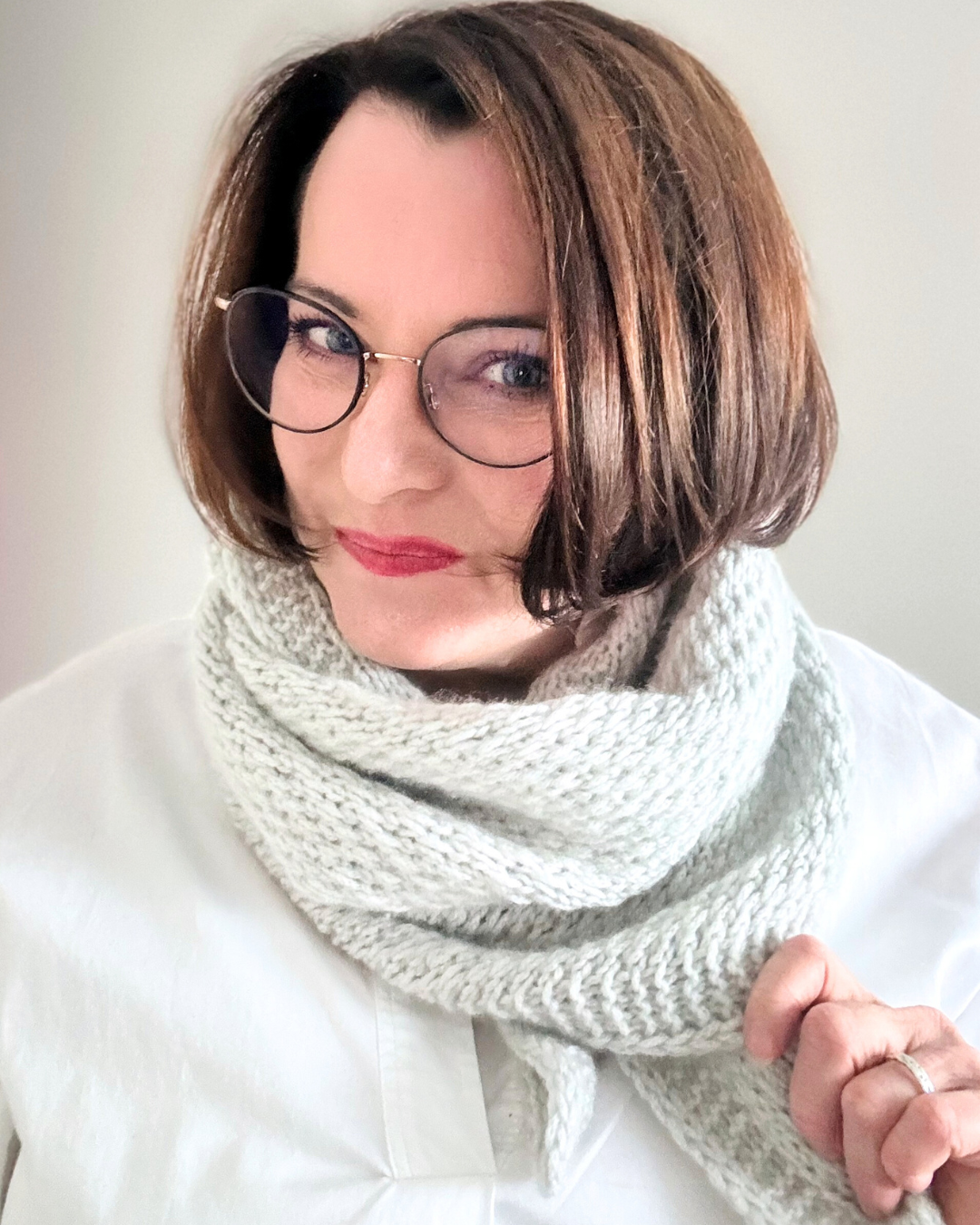 Lyn Embrace – vielseitiges Schultertuch in hellem Grau, gestrickt mit Pascuali Delizia.
