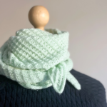 Kleines minigrünes Halstuch auf Schneiderpuppe mit dunkelblauem Pullover. Celeo Design von StrickFisch